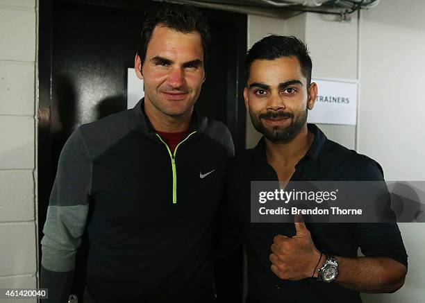 Roger Federer of Switzerland poses with Indian test cricket captain Virat Kohli following his match against Lleyton Hewitt of Australia at Qantas...