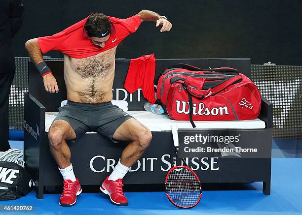 Roger Federer of Switzerland changes his shirt between sets in his match against Lleyton Hewitt of Australia at Qantas Credit Union Arena on January...