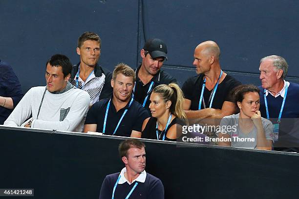 Bernard Tomic, David Warner and Candice Falzon look on at the Lleyton Hewitt of Australia vs Roger Federer of Switzerland during their match at...