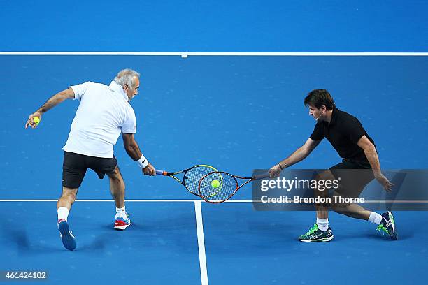 Mansour Bahrami and Fabrice Santoro of France compete for a ball during a Fast4 Legends tennis doubles exhibition match prior to the Roger Federer...