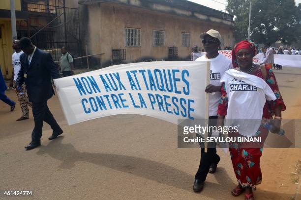 People hold a banner during a march on January 11, 2015 in Conakry, in tribute to the 17 victims of a three-day killing spree by Islamists in Paris....