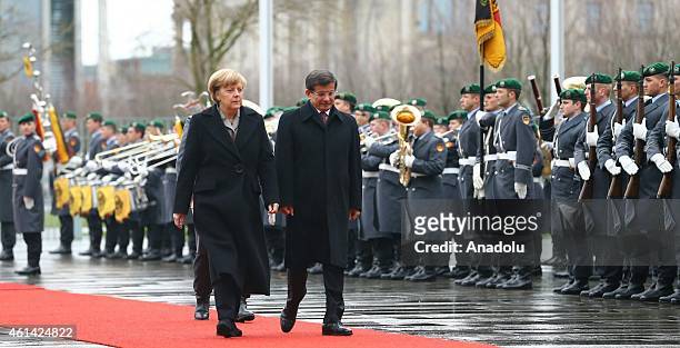 German Chancellor Angela Merkel walks with Turkish Prime Minister Ahmet Davutoglu within the official honor guards' welcoming ceremony during...