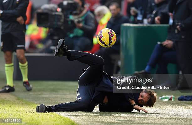 Head coach FC Internazionale Roberto Mancini falls to the ground after being struck by a ball on the touchline during the Serie A match between FC...