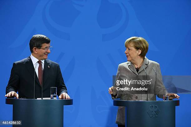 German Chancellor Angela Merkel delivers a speech as Turkish Prime Minister Ahmet Davutoglu listens to her during a joint press conference held after...