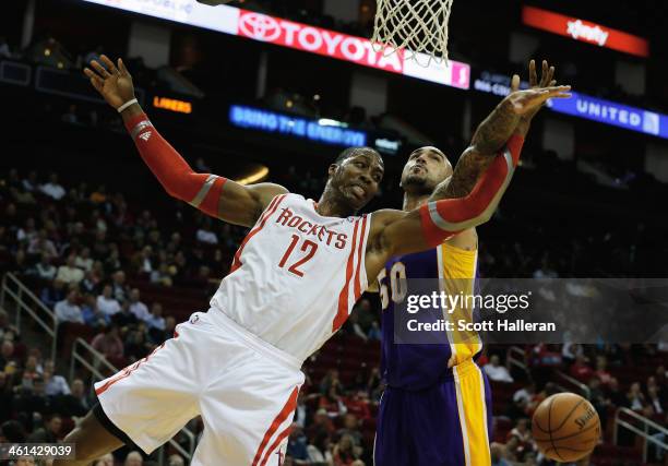 Dwight Howard of the Houston Rockets battles for the ball against Robert Sacre of the Los Angeles Lakers during the game at the Toyota Center on...