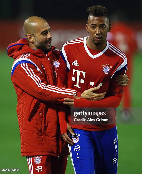 Head coach Pep Guardiola hugs Jerome Boateng during day 4 of the Bayern Muenchen training camp at ASPIRE Academy for Sports Excellence on January 12,...