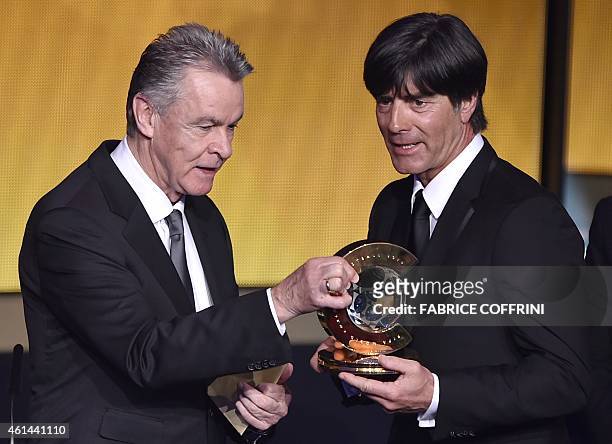 Germany's coach Joachim Loew receives from Switzerland's German coach Ottmar Hitzfeld the 2014 FIFA World Coach of the Year for Men's Football award...