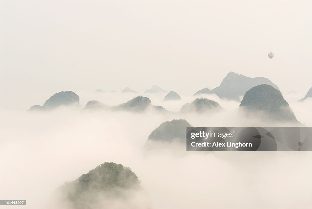 Hot air balloon ride at dawn over Karst mountains