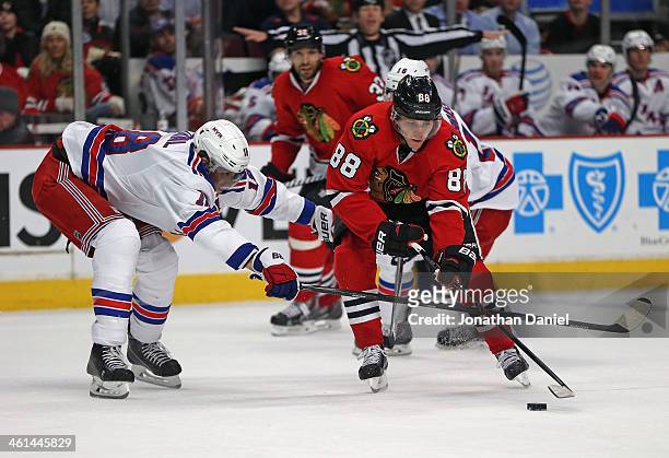 Patrick Kane of the Chicago Blackhawks tries to get off a shot under pressure from Marc Staal of the New York Rangers at the United Center on January...
