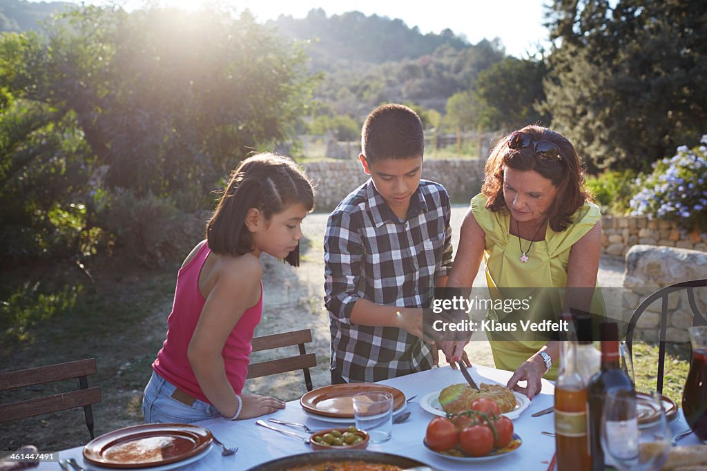 Grandmother helping grandchildren with food