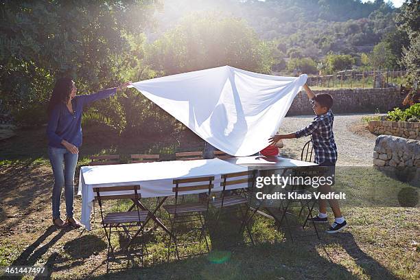 family preparing dinner table - party preparation stock pictures, royalty-free photos & images