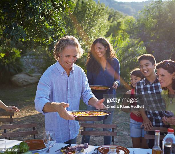 multigenerational family setting dinner table - party pies imagens e fotografias de stock