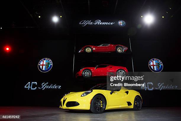 An Alfa Romeo 2015 4C Spider, bottom, and an Alfa Romeo 2015 4C Coupe, middle, both produced by Fiat Chrysler Automobiles NV, sit on display during...