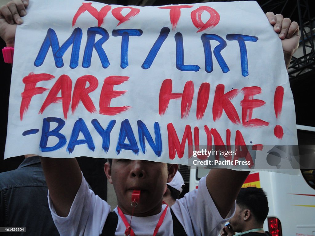 A protester blows a whistle to protest the increase in...