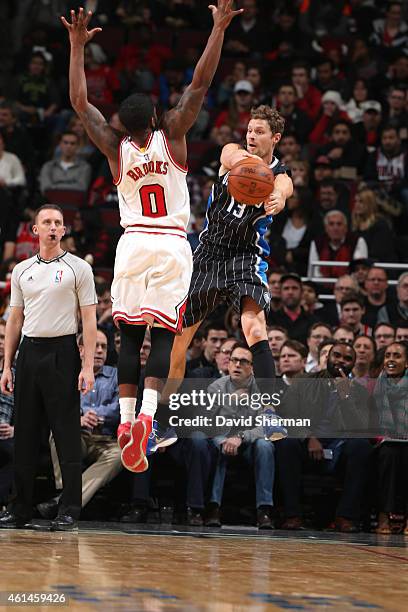 Luke Ridnour of the Orlando Magic passes the ball around Aaron Brooks of the Chicago Bulls on January 12, 2015 at the United Center in Chicago,...