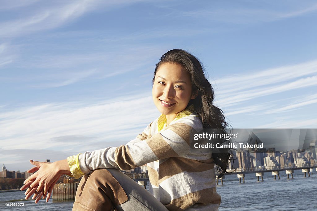 Young woman sitting by river