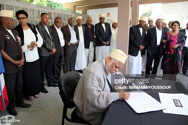Former Comoros president Ahmed Abdallah Sambi signs a condolences book during a memorial service for the people killed during the attacks on the...