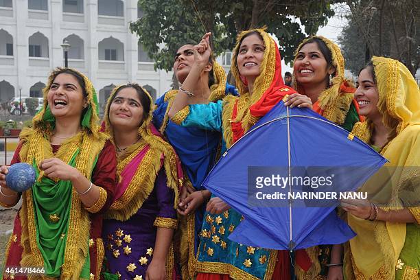 Indian college girls fly kites during celebrations of the Lohri festival in Amritsar on January 13, 2015. The Lohri harvest festival, which falls on...