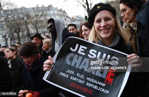 Woman holds a placard reading "Je suis Charlie" during a Unity rally Marche Republicaine in Paris on January 11, 2015 in tribute to the 17 victims of...