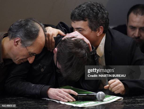 French cartoonist Renald Luzier, aka Luz , is comforted by editor in chief of French satirical weekly Charlie Hebdo Gerard Briard and editorialist Dr...