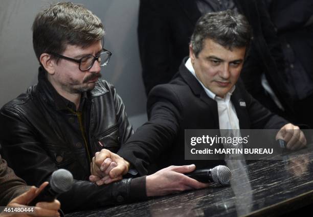 French cartoonist Renald Luzier, aka Luz, and Charlie Hebdo columnist Dr Patrick Pelloux comfort each other as they hold a press conference to...