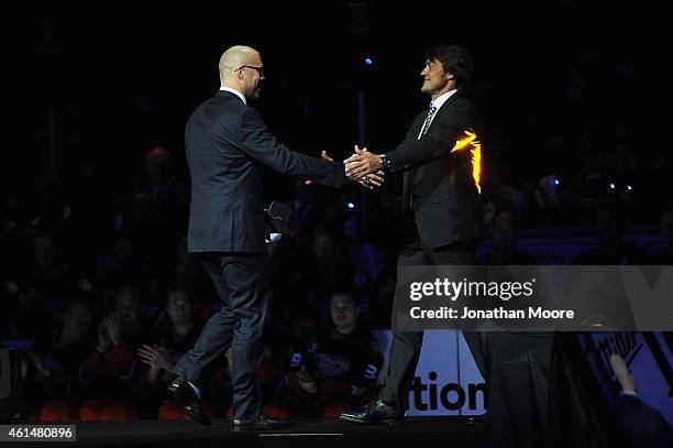 Former Anaheim Ducks player Teemu Selänne shakes hands with former NHL player Jean-Sébastien Giguère during his jersey retirement ceremony for prior...