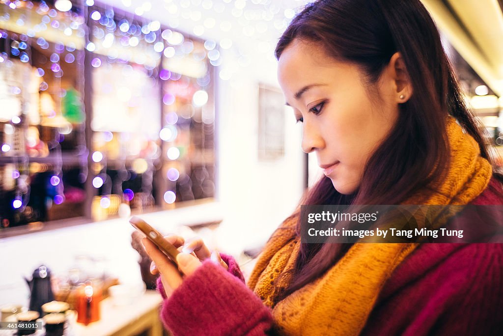 Young lady using smartphone in shopping mall