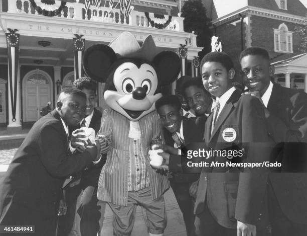 The Boys Choir of Harlem visits Epcot Center and stands with Mickey Mouse at Disney World, Lake Buena Vista, Florida, 1980.