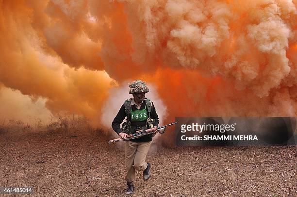 An Indian Border Security Force woman commando runs from thick smoke during an excercise at the Kharkan Training Camp at Hoshiarpur, around 60 kms...
