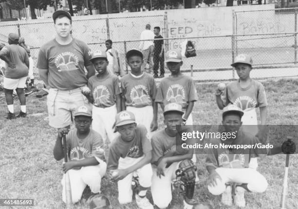 African American youth, coaches and community members gather for a little league baseball game, Harlem Park, Baltimore, Maryland, 1980.