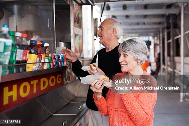 senior couple buying food from street vendor - snack stand stock pictures, royalty-free photos & images