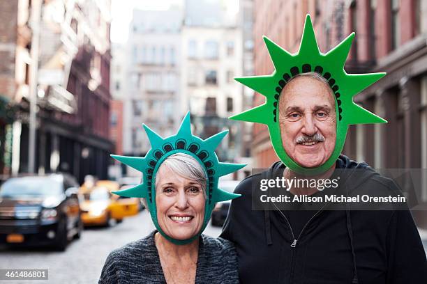 senior couple portrait with liberty hats - new york tourist stockfoto's en -beelden