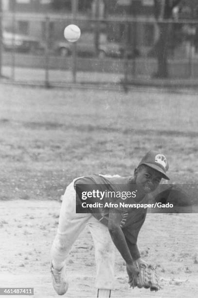 An African American youth throw a pitch during a little league baseball game, Baltimore, Maryland, 1980.