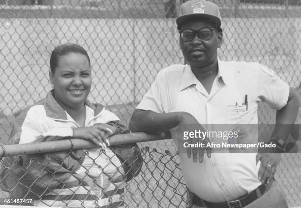 United States Postal Service employee serves as a coach for little league baseball, Harlem Park, Baltimore, Maryland, 1980.