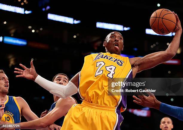 Guard Kobe Bryant of the Los Angeles Lakers drives the lane into defenders Klay Thompson and David Lee of the Golden State Warriors during first...