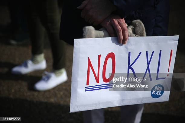 An activist holds a sign during a protest in front of the White House against the Keystone XL pipeline January 13, 2015 in Washington, DC. Activists...
