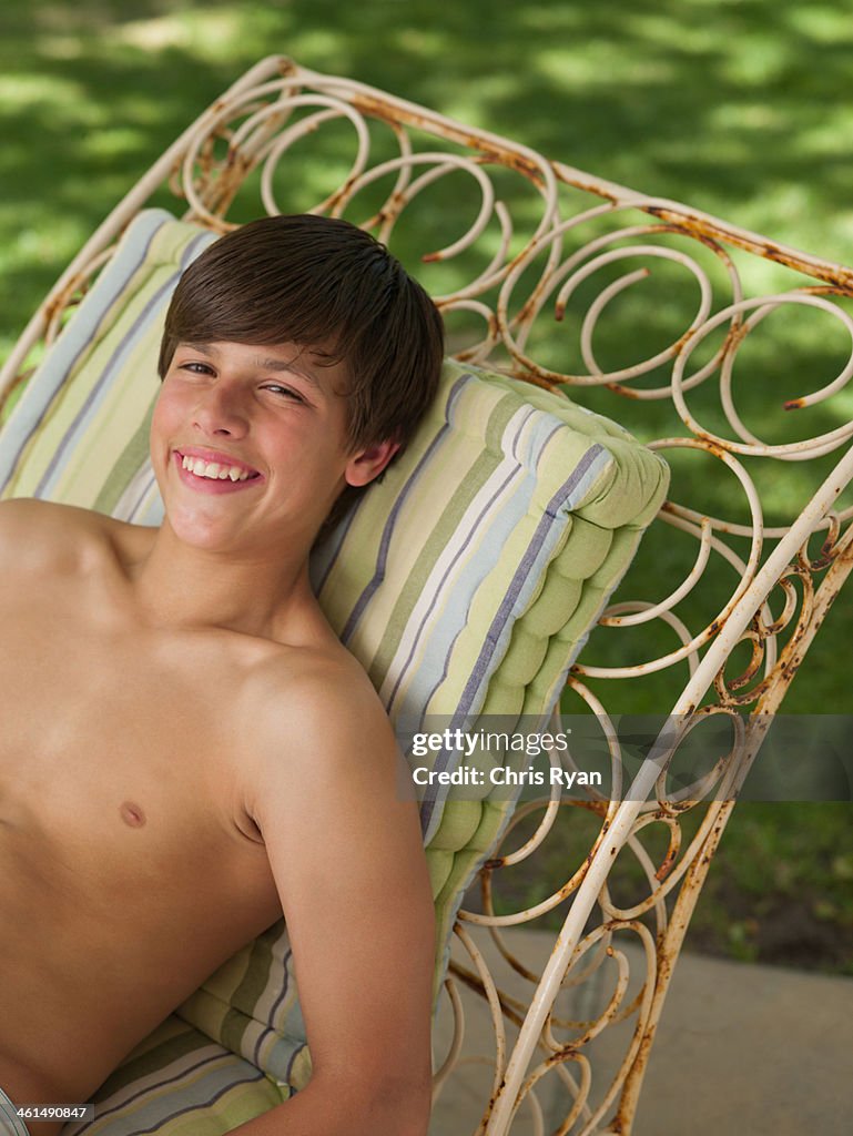 Boy relaxing outdoors in summer smiling