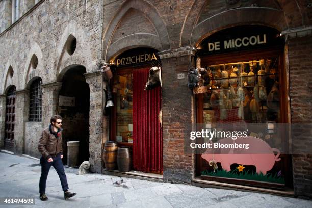 Pedestrian passes a delicatessen store in Siena, Italy, on Wednesday, Jan. 8, 2014. Banca Monte dei Paschi di Siena SpA, the bailed out Italian bank,...