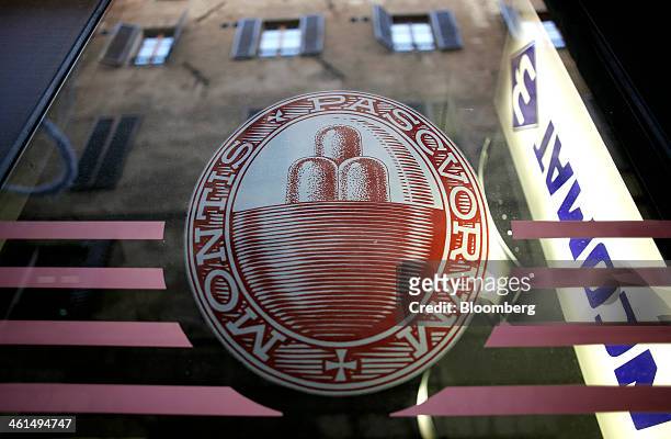 Logo sits on the window of a Banca Monte dei Paschi di Siena SpA bank branch in Siena, Italy, on Wednesday, Jan. 8, 2014. Monte Paschi, the bailed...