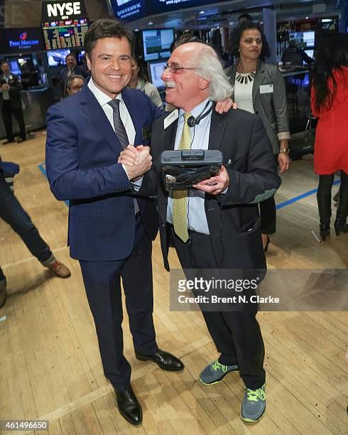 Entertainer Donny Osmond poses with a trader prior to ringing the NYSE closing bell to celebrate the release of his 60th album at the New York Stock...