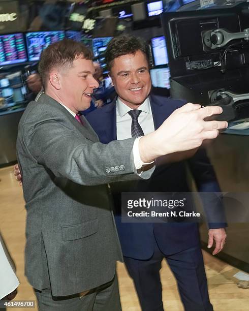 Entertainer Donny Osmond takes a selfie with a trader prior to ringing the NYSE closing bell to celebrate the release of his 60th album at the New...