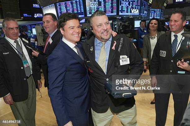 Entertainer Donny Osmond poses with a trader prior to ringing the NYSE closing bell to celebrate the release of his 60th album at the New York Stock...