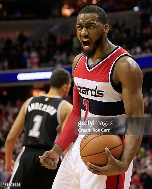 John Wall of the Washington Wizards celebrates in front of Kyle Anderson of the San Antonio Spurs after the Wizards defeated the Spurs 101-93 at...