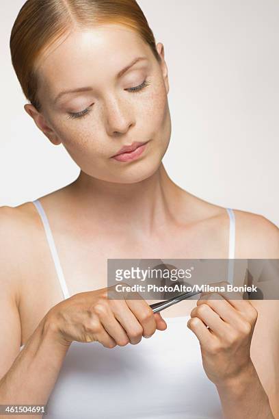 young woman cutting cuticle - nagelhaut stock-fotos und bilder