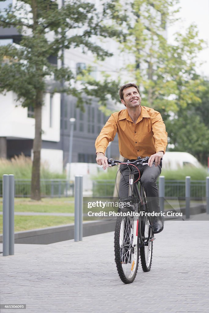 Man in business attire riding bicycle