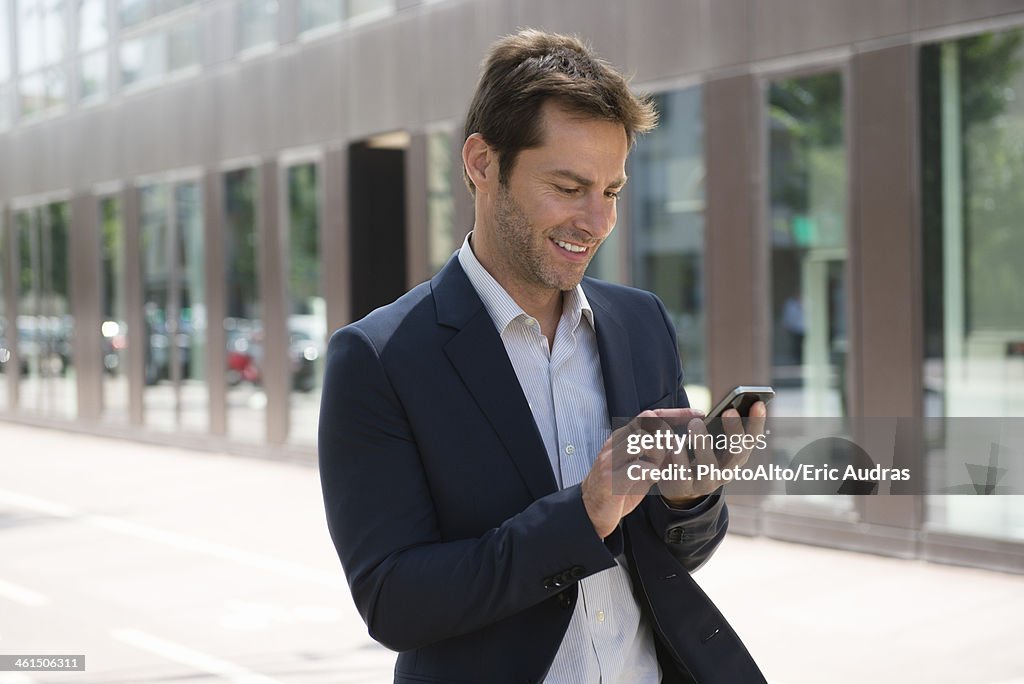 Businessman using smartphone outdoors