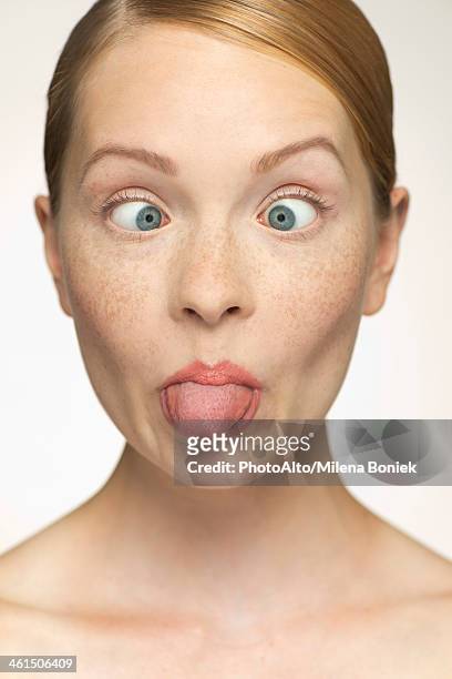 young woman sticking out tongue - scheel kijken stockfoto's en -beelden