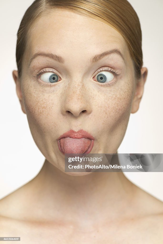 Young woman sticking out tongue