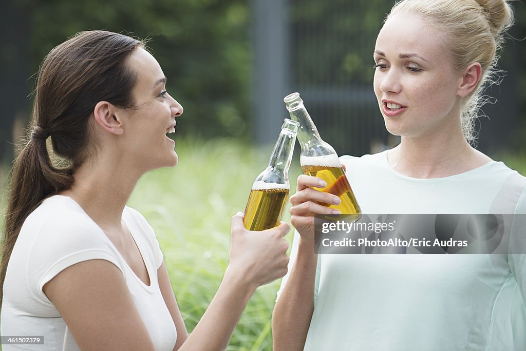 Women drinking together, clinking bottles