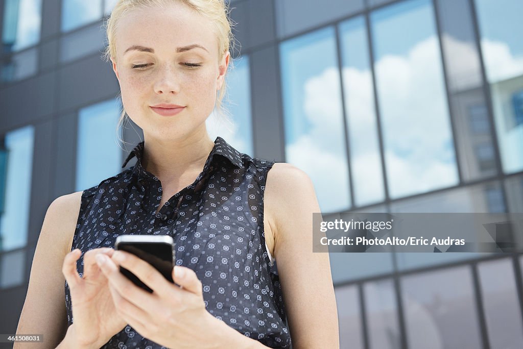 Young businesswoman using smartphone outdoors